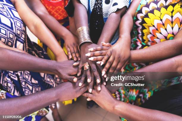grupo de mujeres africanas que se unen a las manos en unity - zambia fotografías e imágenes de stock