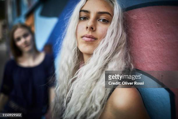 portrait of young woman with friend at a graffiti wall - woman face art stock pictures, royalty-free photos & images