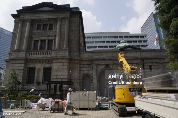 Construction worker walks past the Bank of Japan headquarters in Tokyo, Japan, on Thursday, June 20, 2019. The BOJ kept monetary policy unchanged,...