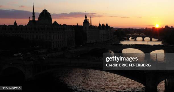 This picture taken at sunset on April 29, 2019 in Paris shows an aerial view of the Seine river banks, the Notre Dame Bridge, the Saint-Chapelle, the...