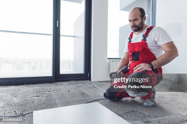 professionele tegelzetter snij vloer tegel - kniebeschermer stockfoto's en -beelden