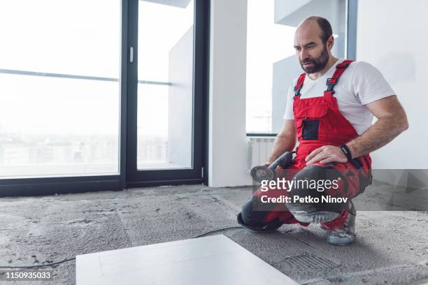 professional tiler cutting floor tile - kneepad stock pictures, royalty-free photos & images