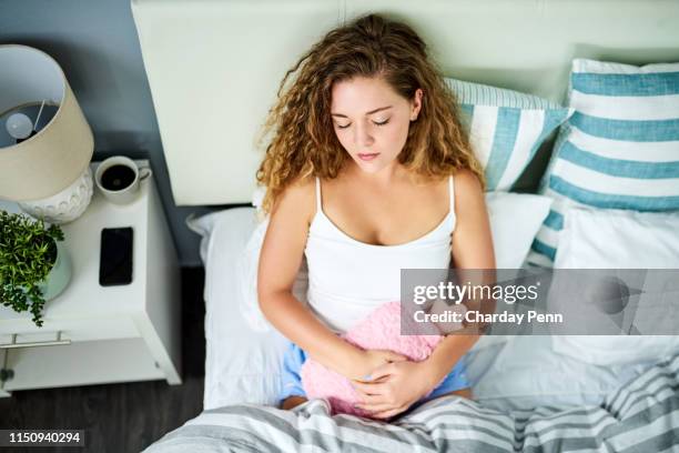 die wärme lindert die schmerzen und beschwerden - wärmflasche stock-fotos und bilder