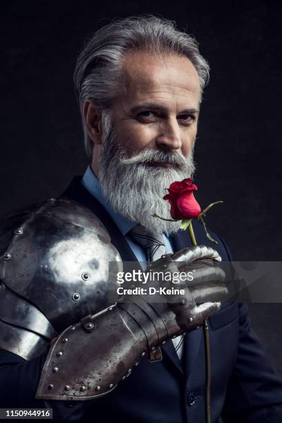 classy dressed senior businessman with red rose - knight person stock pictures, royalty-free photos & images