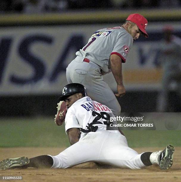 Venezuelan player Miguel Cairo takes out Abraham Nunez of the Dominican Republic 06 February 2001 in Culiacan, Mexico. The Dominican won 8-6. Miguel...