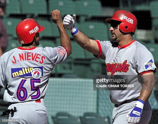 First baseman of Venezuela's los Cardenales de Lara Luis Raven congratulates his teammate Joes Nieves after hitting a homerun in the Caribbean Series...