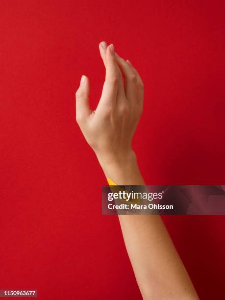 first aid adhesive plaster on woman's wrist against red background - hand laceration stockfoto's en -beelden