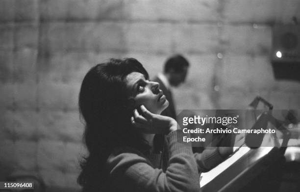 Italian actress Sophia Loren, smoking a cigarette, dubbing the movie 'El Cid', wearing a pullover, holding headphones, Rome 1961.