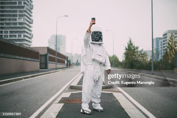 astronaut taking selfie in middle of road - astronaut potrait stock pictures, royalty-free photos & images