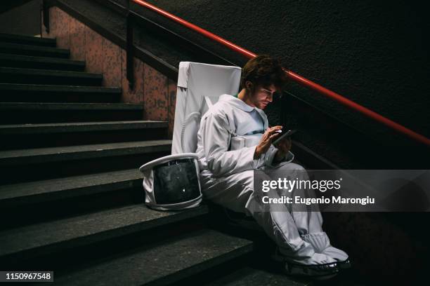 astronaut using smartphone on stairway - asentamiento humano fotografías e imágenes de stock