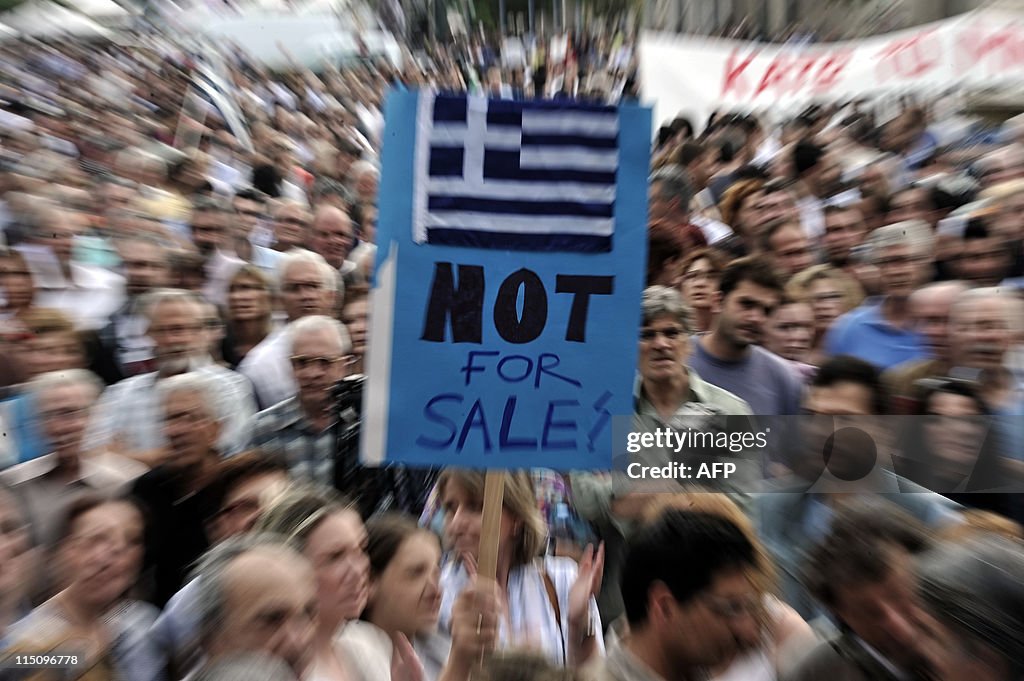 People hold a placard depicting the Gree