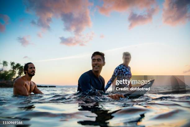 surfers gliding in sea at sunset, pagudpud, ilocos norte, philippines - daily life in philippines stock-fotos und bilder