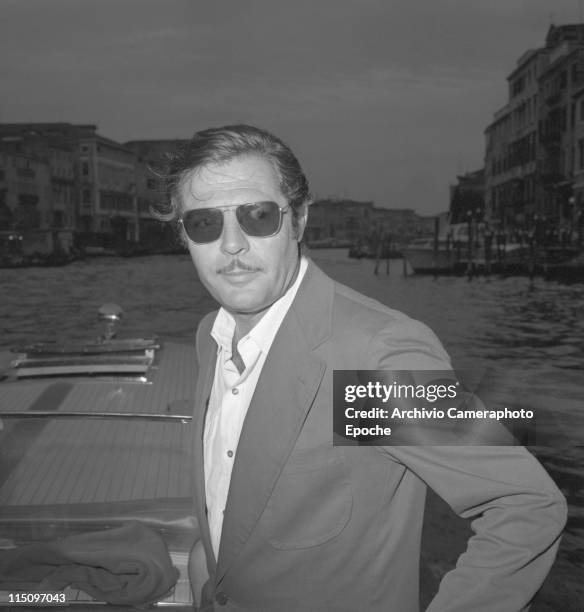 Italian actor Marcello Mastroianni, wearing a blazer and sunglasses, portrayed on a water taxi on a trip along the Grand Canal, in Venice for the...