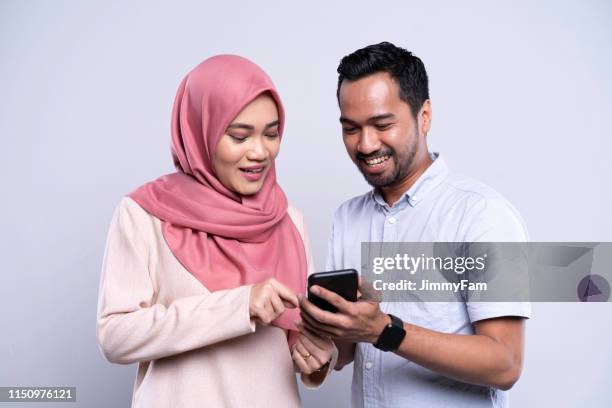 asian malay couple sharing information on smartphone. - malay couple stock pictures, royalty-free photos & images