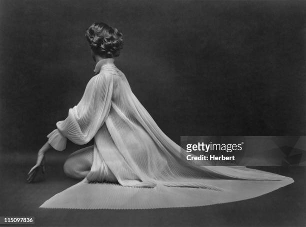 Woman wearing a fine pleated dress poses in the 1950's.