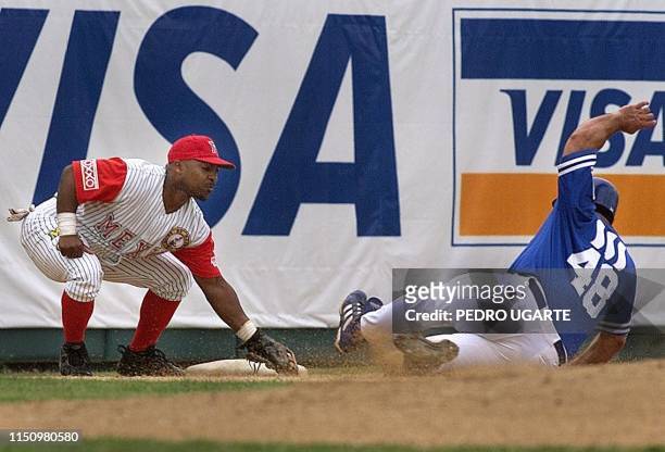 Hector Villanueva of Mexico slides into third base as Puerto Rico's Hector Villanueva looks for the tag, 06 February 2000 in Santo Domingo. El...