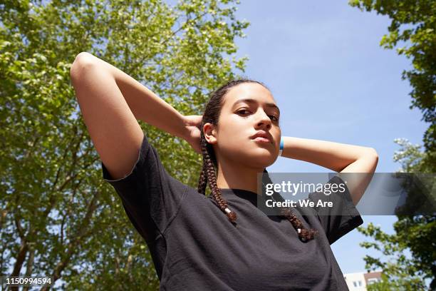 low angle view of young woman with hands behind head - low confidence stock pictures, royalty-free photos & images