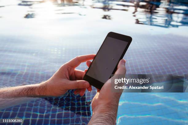using smartphone in the swimming pool - cell phone pool stock pictures, royalty-free photos & images