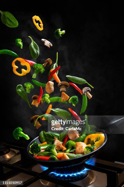 flying chicken and vegetable stir fry, in una padella - volare foto e immagini stock