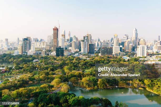 bangkok cityscape with lumpini park and modern skyscrapers, aerial view - business park stockfoto's en -beelden