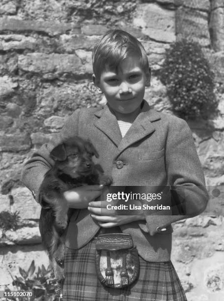 Prince Richard of Gloucester with his pet puppy at his home at Barnwell Manor, Northamptonshire in June 1952.