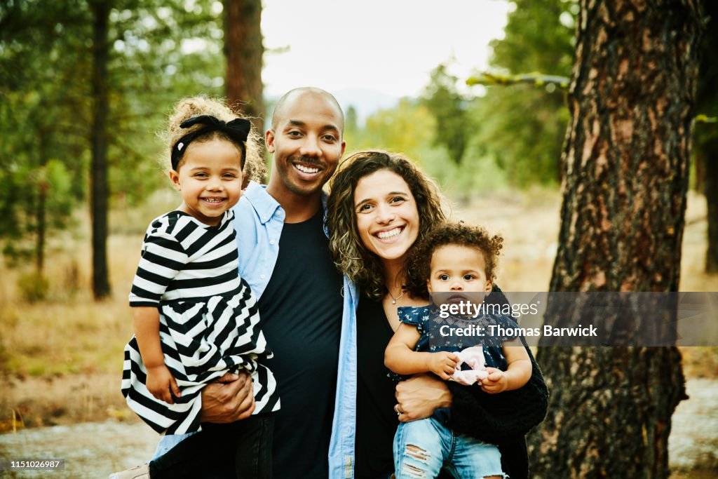 Portrait of smiling parents holding two young daughters