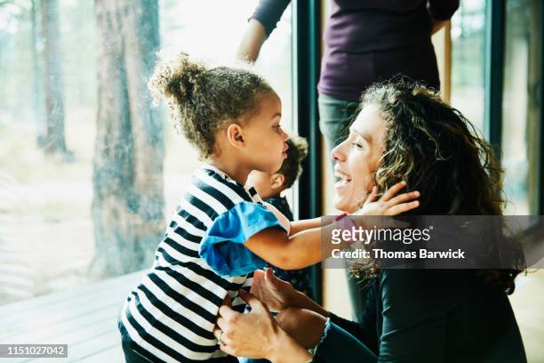 Young girl about to kiss laughing mother