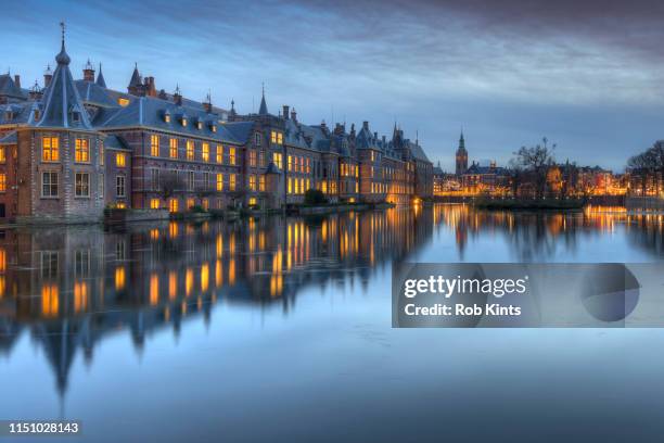 dutch houses of parliament ( het torentje and binnenhof ) in den haag reflected in the court pond ( hofvijver ) after sunset - la haya fotografías e imágenes de stock