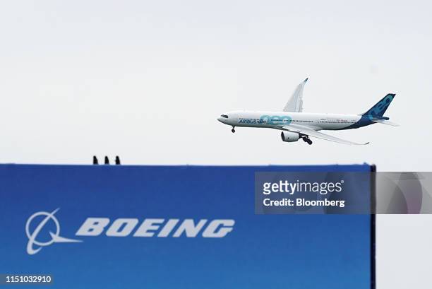 An Airbus SE A330neo passenger aircraft flies past the Boeing Co. Exhibition area during the 53rd International Paris Air Show at Le Bourget, in...