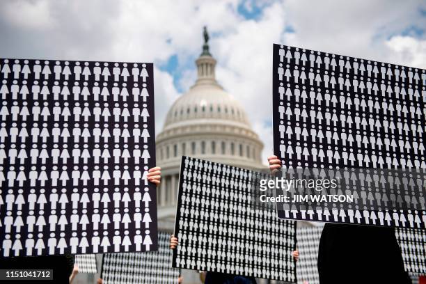 Demonstrators hold up placards representing the number of the people who have died due to gun violence on Capitol Hill in Washington, DC, on June 20...