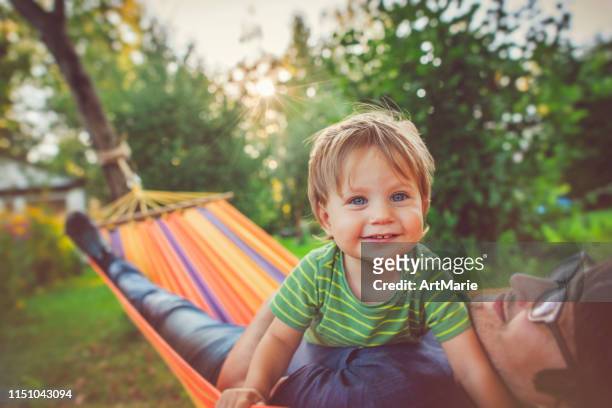 family enjoying spring/summer day in hammock - backyard hammock stock pictures, royalty-free photos & images