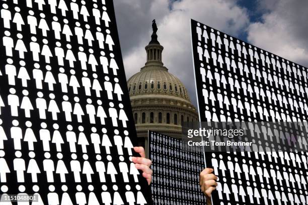 Demonstrators hold up signs representing the 11,400 victims of gun violence discussed by congressional members during a press conference with...