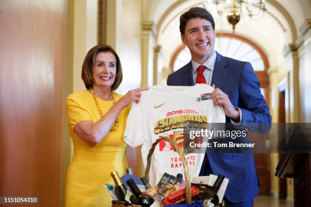 Canadian Prime Minister Justin Trudeau holds up a Toronto Raptors NBA championship shirt presented to U.S. House Speaker Nancy Pelosi on Capitol Hill...