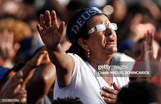 Woman prays as she attends the 27th edition of the "March for Jesus" to celebrate Corpus Christi, an event that gathers a wide range of evangelical...