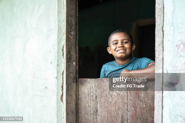 brasilianischer junge steht hinter einer holländischen tür - humility stock-fotos und bilder