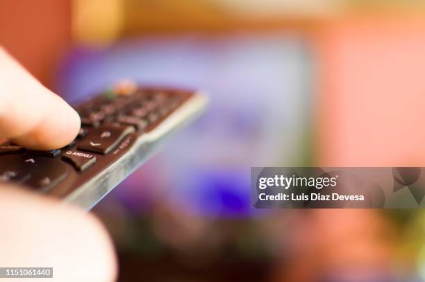man using tv remote control - access control cartoon stock pictures, royalty-free photos & images