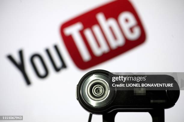 In this file photo taken on June 28, 2013 a webcam is positioned in front of YouTube's logo in Paris. - Millions of children regularly use YouTube to...