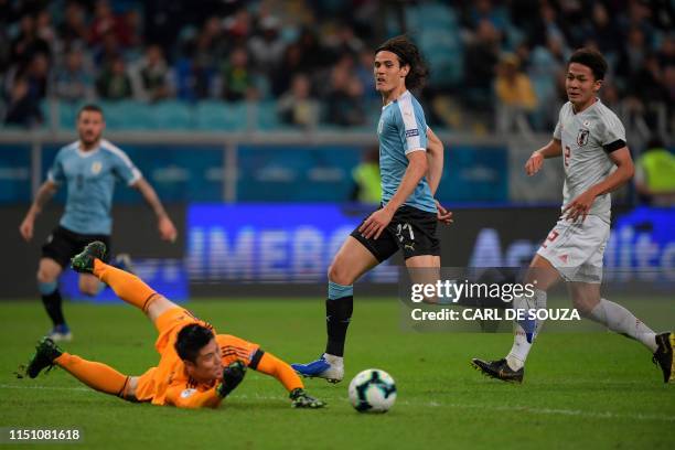 Uruguay's Edinson Cavani shoots at goal as Japan's goalkeeper Eiji Kawashima makes a save during the Copa America football tournament Group C match...