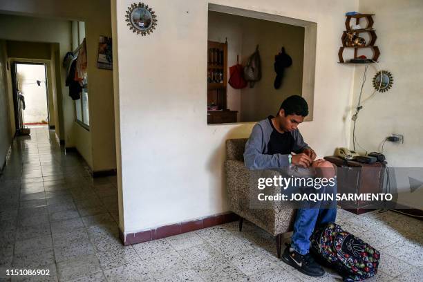 Teenage student Miguel Angel Suarez, takes care of a baby robot at his home in Caldas, Antioquia's department, Colombia on May 19, 2019....