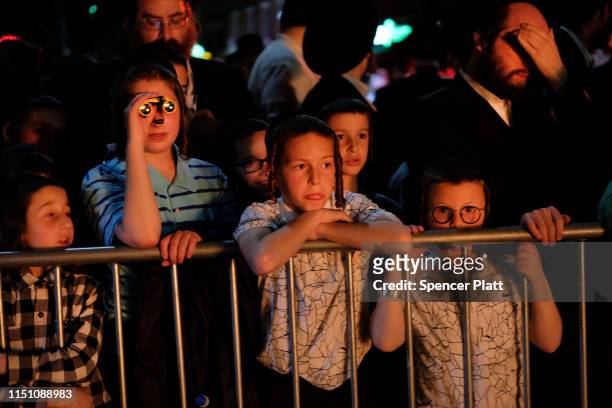 Orthodox children and adults watch as a traditional bonfire is lit to celebrate the Jewish holiday of Lag B’omer in the Borough Park neighborhood of...