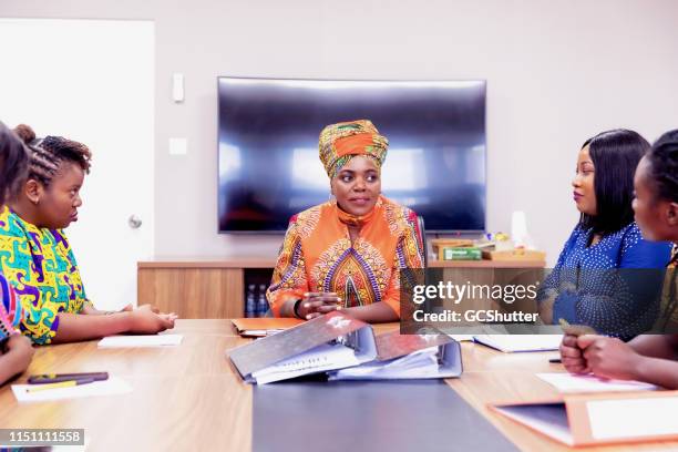 confident businesswoman wearing traditional chitenge chairing the boardmeeting - head tie stock pictures, royalty-free photos & images