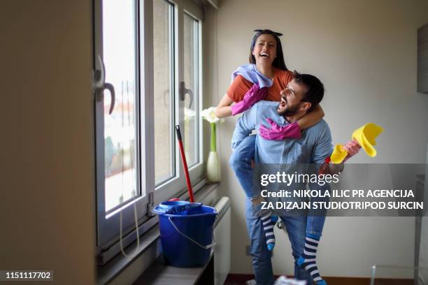 bel appartement de ménage de couples mariés de jeunes - gant-de-ménage photos et images de collection