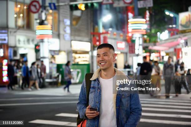 man standing at a cross walk in a busy asian city - taipei stockfoto's en -beelden
