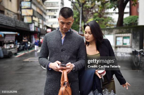 couple checking directions on their phone - taipei business stock pictures, royalty-free photos & images