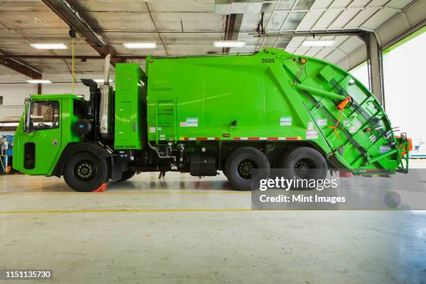 green garbage truck maintenance - garbage truck fotografías e imágenes de stock