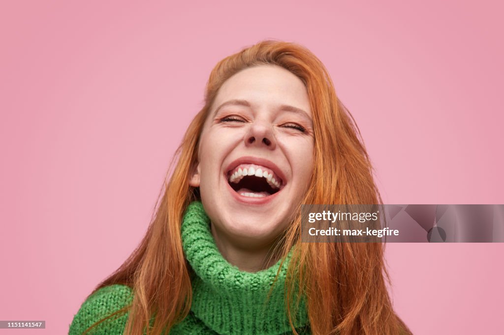 Maravillosa chica riendo sobre fondo rosado