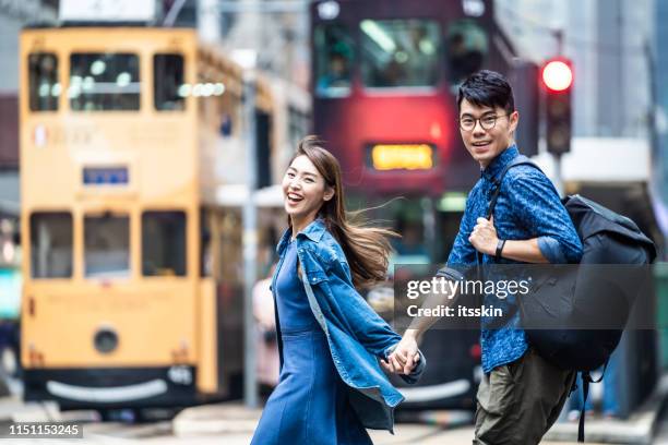 two people walking in hong kong and holding hands. - china tourism stock pictures, royalty-free photos & images