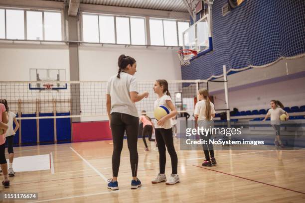 volleyball coach talking to a group of girls on training - candid volleyball stock pictures, royalty-free photos & images