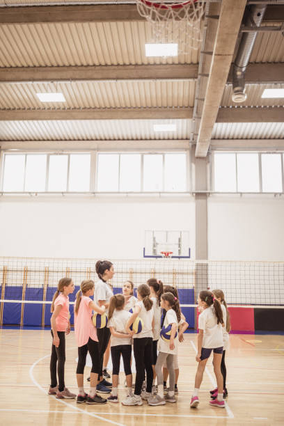 volleyball coach talking to a group of girls on training - girls volleyball stock pictures, royalty-free photos & images