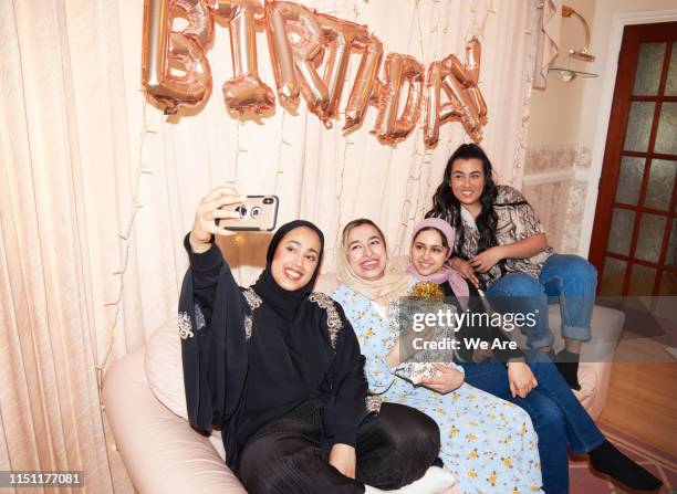 young muslim women taking a birthday party selfie - camera flashes foto e immagini stock